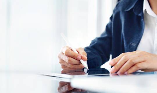 Cropped close-up of a team member using a stylus pen with tablet