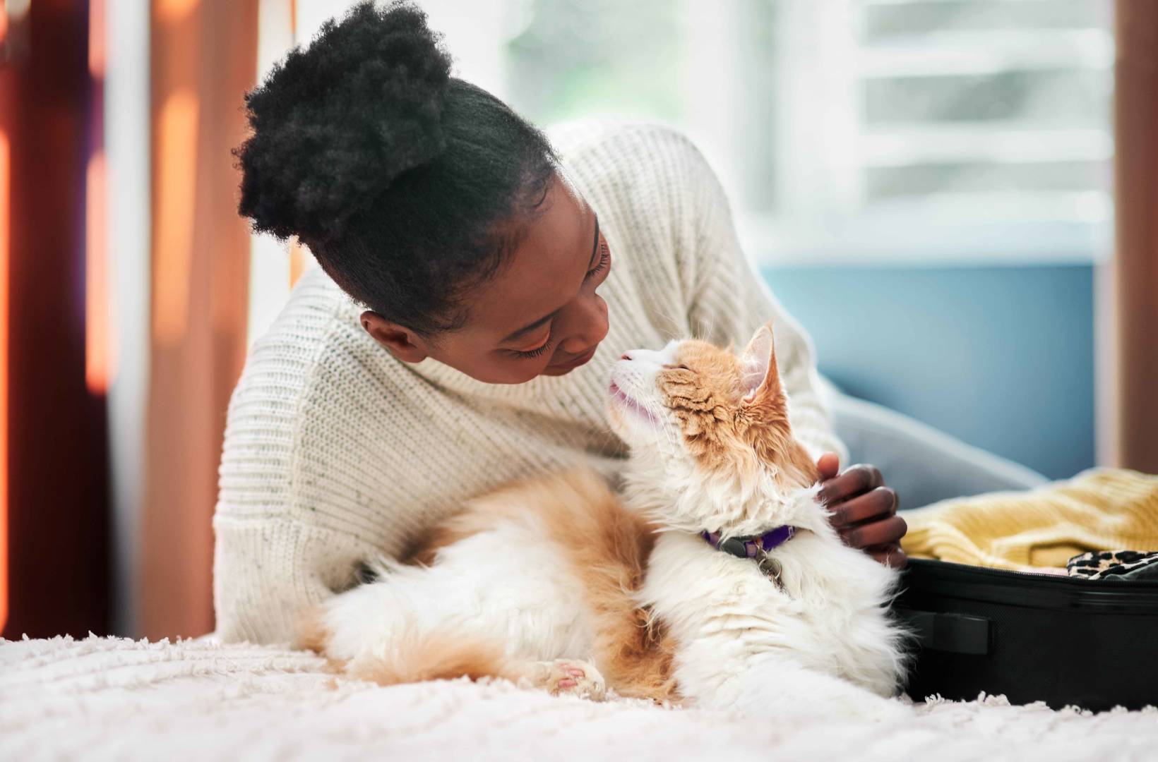 Woman petting and being close with her cat at home