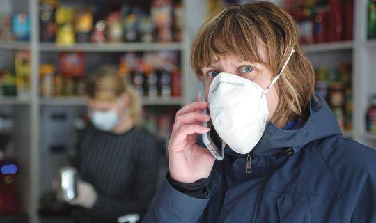 Store employee wearing a protective facemask while on the phone